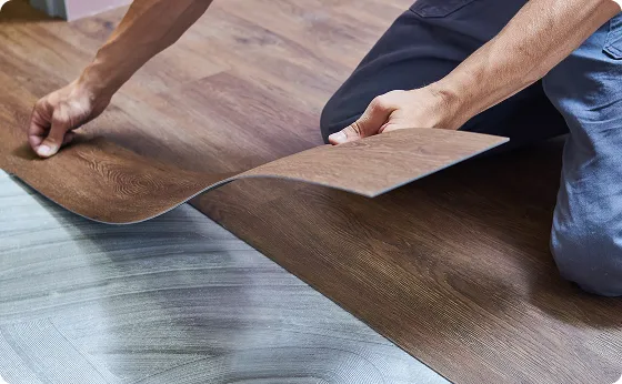 Handwerker verlegt Klick-Vinylboden in Holzoptik