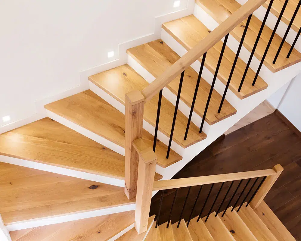 Renovierte Treppe mit hellen Eichenstufen und Holzgeländer im Treppenhaus